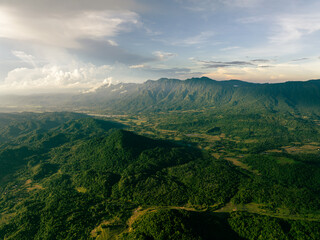 Obraz premium Sunset Over Verdant Tropical Mountain Peaks