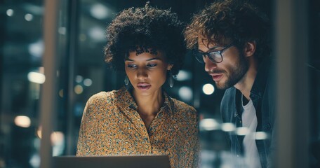 Portrait of Two Creative Young Female and Male Engineers Using Laptop Computer to Analyze and Discuss How to Proceed with the Artificial Intelligence Software. Standing in High Tech Research Office