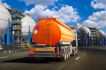 Fuel tanker truck driving through a chemical or gas storage facility with large spherical tanks and...