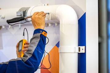 Fototapeta na wymiar Technical diagnostics gas detector. Device for finding gas leaks. Technical diagnostics of pipes after installation. Gas company employee is looking for propane leak. Energy infrastructure security