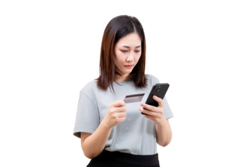 Asian young beautiful woman holds a credit card and a smartphone, appearing to make an online transaction.