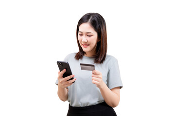 Fototapeta premium Asian young beautiful woman holding a smartphone and a credit card, smiling while making an online payment.