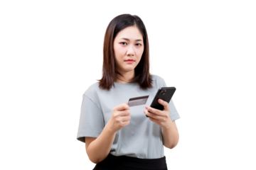 Asian young beautiful woman holding a credit card and a smartphone, appearing cautious while making an online transaction.