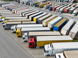 Plakat Aerial view of a large truck parking lot at a logistics hub, with multiple commercial semi trucks parked in organized rows