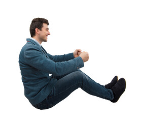 Side view full length portrait of a young smiling businessman driving an imaginary car isolated on...