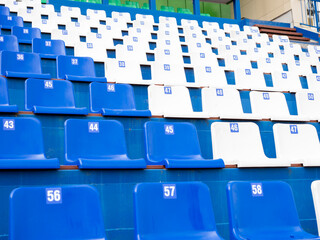 Fototapeta premium A row of blue and white stadium seats with numbers on them