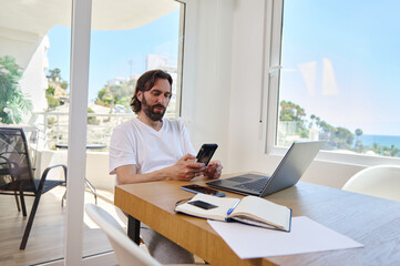 Man Working Remotely From Home Using Technology in a Bright Minimalist Interior