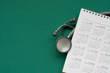 Top view of stethoscope and calendar on the table background, schedule to check up healthy concept