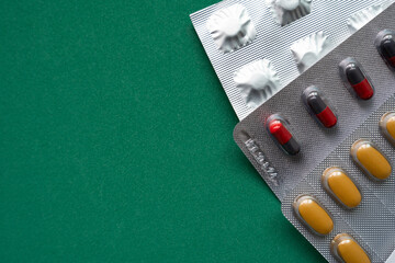 many colorful drug medicines or pill on green table, healthy and medicine concept