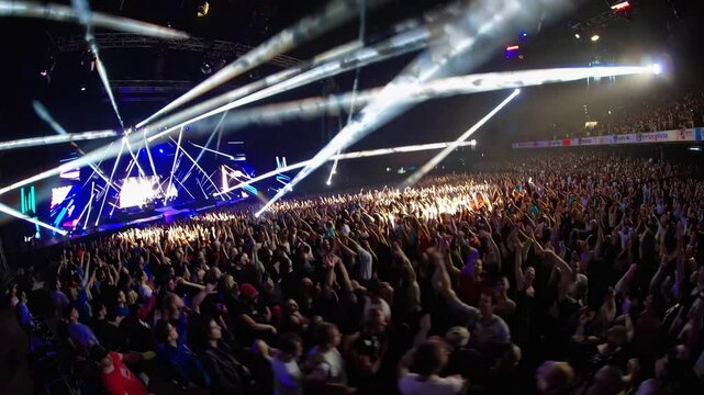 Energetic concert crowd with vibrant lights and dynamic stage effects captures live music excitement