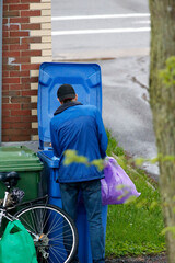 Un homme cherche des bouteilles vides dans les poubelles. Pauvreté urbaine.	