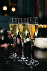 Close-up of three champagne flutes with bubbles.