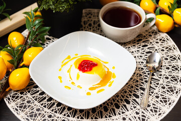 Panna cotta dessert with fruit sauce and tea.