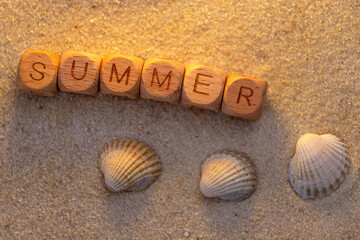 Summer beach vibes. Wooden blocks spelling summer. seashells in golden sand