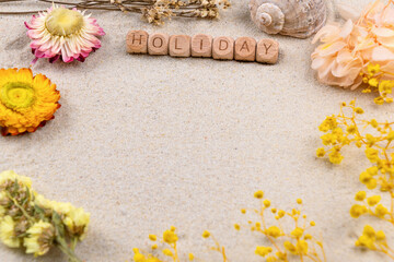 Holiday concept with flowers and shell on sandy background