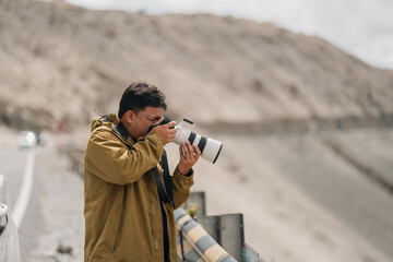 Fototapeta premium Photographer exploring Leh Ladakh with professional camera gear, capturing breathtaking mountain landscapes and documenting adventure travel in Northern India Himalayan region