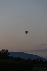 A colorful hot air balloon gracefully floating in the soft, warm light of early morning. The serene sky and gentle sunlight create a peaceful and inspiring scene, perfect for capturing the magic.