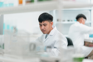 Researchers collaborate in a cutting-edge DNA laboratory, analyzing samples on petri dishes to...