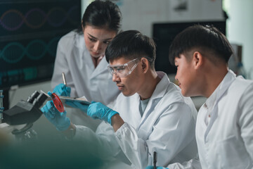 Researchers collaborate in a cutting-edge DNA laboratory, analyzing samples on petri dishes to...