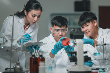 Researchers collaborate in a cutting-edge DNA laboratory, analyzing samples on petri dishes to...