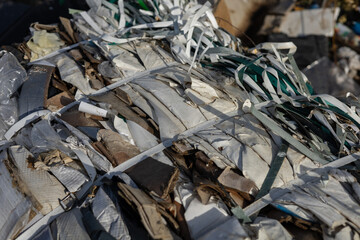 Compacted waste materials are securely bound with straps at a landfill site, highlighting the challenges of pollution and waste management