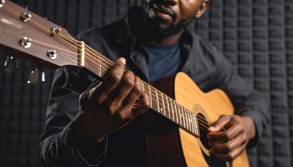 Acoustic Guitarist: Close-up of a man's hands playing an acoustic guitar in a recording studio. The image evokes a sense of musical passion and skill. 