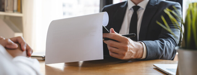 Close-up hands of interviewer on the table during asking question applicant in the office.