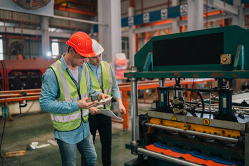 An industrial worker operates machinery in a modern factory environment focusing on production...