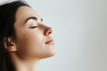 Fototapeta premium Side view of acupuncture therapy on a woman's face