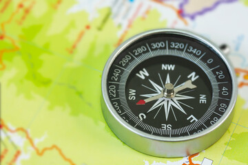 selective focus of compass on blurred map background.