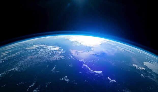 The layered view of Earth&rsquo;s atmosphere from orbit, with a blue gradient against the space void, slowly rotates. Sunlight crests the edge of the planet