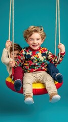 Two children joyfully swing on a bright red and yellow swing set