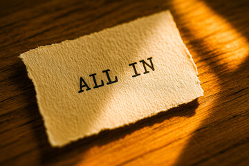 Motivational Text “ALL IN” on Torn Paper in Golden Light