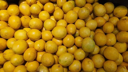 Close up pile of tasty fresh oranges sold at the market as a background.