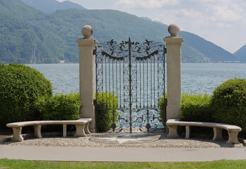 Garden gate at Ciani Park in Lugano leading to Lake Lugano, Switzerland.