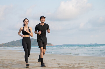 Young men and women run along the sea or beach to promote health, strength and quality of life,...