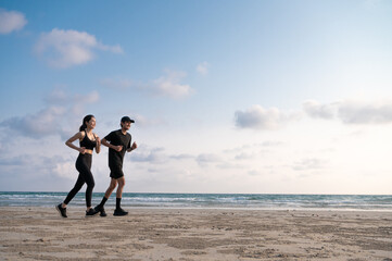 Young men and women run along the sea or beach to promote health, strength and quality of life, emphasizing the concept of fitness, sports and having a healthy lifestyle for both young and old people.