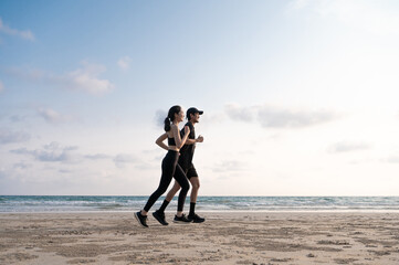 Young men and women run along the sea or beach to promote health, strength and quality of life, emphasizing the concept of fitness, sports and having a healthy lifestyle for both young and old people.