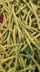 Close up pile of fresh long beans placed together in local market as a background.	