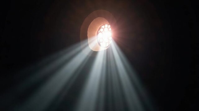 Beam of sacred spiritual light passing through a rose window of a night church