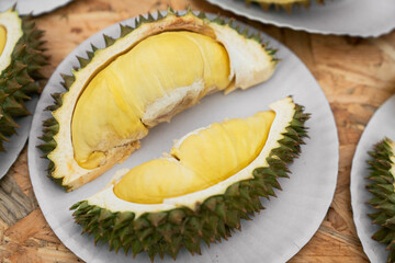 Fototapeta premium Ripe Durian Fruit Halves on Paper Tray – Tropical Thai Delicacy