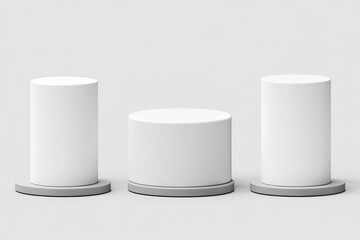 Three white cylindrical display stands on grey bases