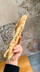 Hand holding a savory stuffed flatbread, tantalizing aromas of za'atar spice blend beckon a Middle...