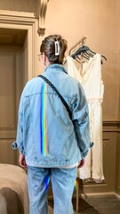 A contemplative Caucasian woman gazes at ivory dresses, rainbow beam slicing denim, bridging...