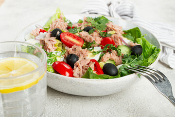 salad with canned tuna, vegetable salad with quail eggs, lettuce and romaine leaves, red onion, cherry tomatoes, olives, keto food, healthy eating,