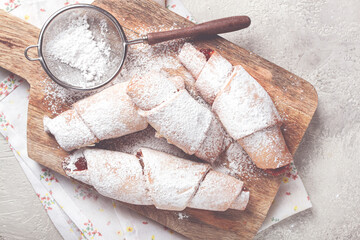 bagels with filling, sweet pastries, sprinkled with powdered sugar, on a wooden board, dessert, breakfast,