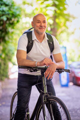 Obraz premium Mid aged man using a bicycle on sthe street downtown
