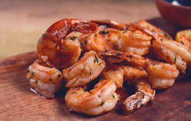 fried tiger prawns, jumbo, in garlic sauce, in butter, with herbs, on a wooden board, homemade, no people,