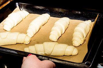 Place a baking tray with uncooked croissants on baking paper inside the oven.