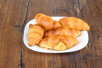 Close-up of freshly baked croissants on a white plate.